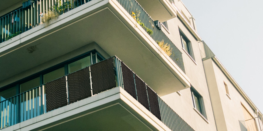 Vooraanzicht van flatgebouw en balkons met Paua's zonnepanelen geïnstalleerd.